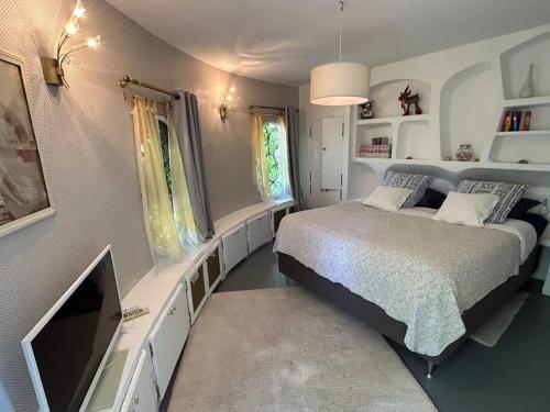 une chambre avec un lit et une télévision à écran plat dans l'établissement Villa Mougins vue Mer sur Baie de Cannes, Piscine vue mer partagée, à Mougins