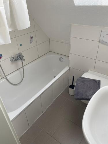a white bathroom with a tub and a sink at Haus Osterstraße in Norden