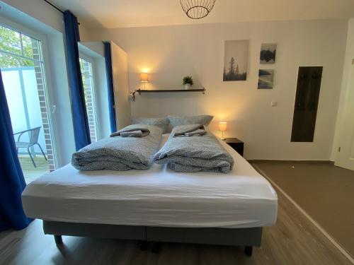 a bed with two pillows on it in a room at Haus Osterstraße in Norden