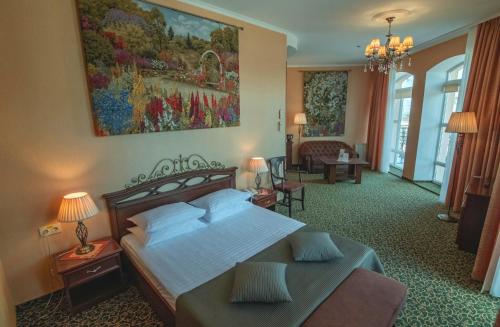 ポルタヴァにあるPremier Hotel Palazzoのベッドとリビングルームが備わるホテルルームです。