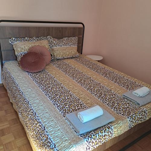 a bed with two pillows and towels on it at Riga Fereou apartments in Patra
