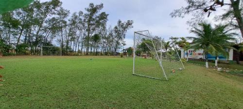 an empty field with a soccer goal in a park at POUSADA ARKAN BEACH in Saquarema