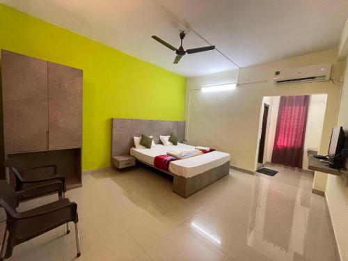 a bedroom with a bed and a yellow wall at Le Green Kaziranga in Hatikhuli