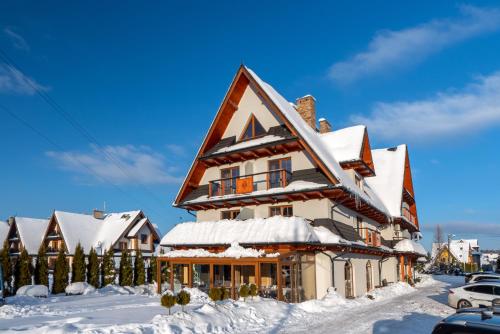 a house covered in snow with snow at Parzenica B&B - Wyjątkowa i Jedyna!!! Sprawdź nas a nie pożałujesz! in Białka Tatrzanska