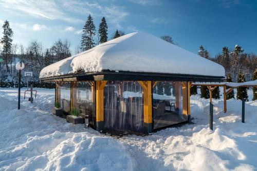 a gazebo with a snow covered roof in the snow at Parzenica B&B in Białka Tatrzańska