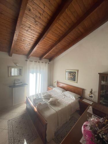 1 dormitorio con 1 cama grande y techo de madera en Il Nido dell’Aquila, en Moncalvo