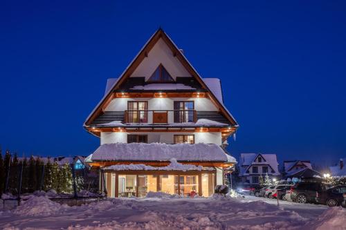 a house covered in snow at night at Parzenica B&B - Wyjątkowa i Jedyna!!! Sprawdź nas a nie pożałujesz! in Białka Tatrzanska