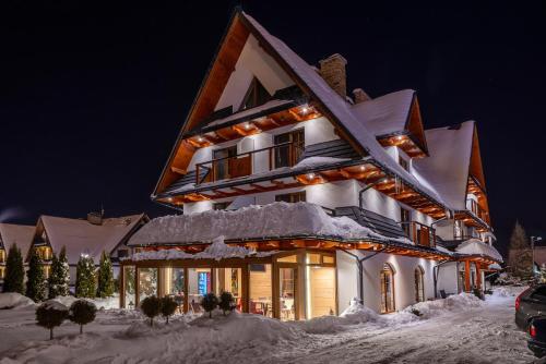 a house covered in snow at night at Parzenica B&B - Wyjątkowa i Jedyna!!! Sprawdź nas a nie pożałujesz! in Białka Tatrzanska