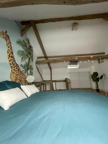 een slaapkamer met een blauw bed met een giraffe aan de muur bij Cottage scandinave in Rouen