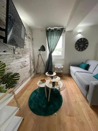 een woonkamer met een bank en een tafel bij Cottage scandinave in Rouen
