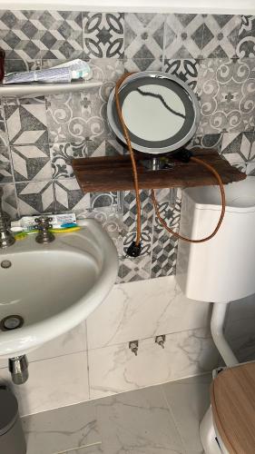 ein Badezimmer mit einem Waschbecken und einem Spiegel auf einem WC in der Unterkunft Bekas Lodge in Siófok