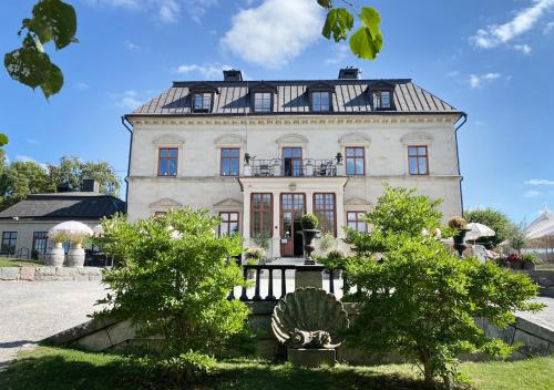 a large white building with a black roof at Görvälns Slott in Järfälla