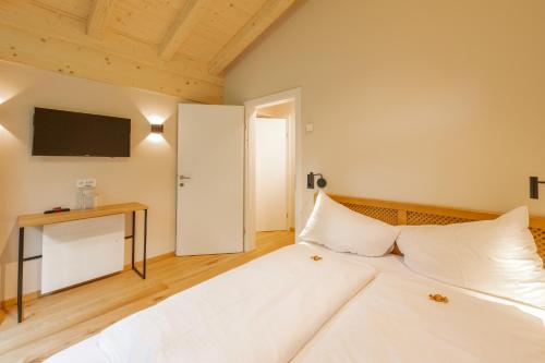 a large white bed in a room with a tv at Haus Jausern in Saalbach Hinterglemm