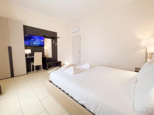 a bedroom with a large white bed and a desk at Brain Apartment Pagani in Pagani