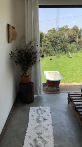 a bath tub in a room with a window and a rug at Atma Anna in Piedade