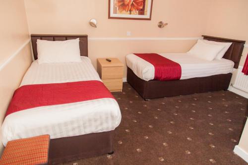 a hotel room with two beds and a table at The Lawton in Blackpool