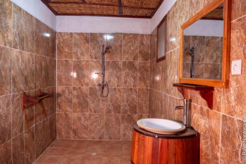a bathroom with a shower with a toilet and a sink at EDEN DE LA TSIRIBIHINA in Miandrivazo