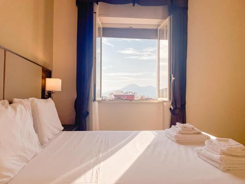 a bedroom with a bed and a window with towels at Brain Apartment Pagani in Pagani