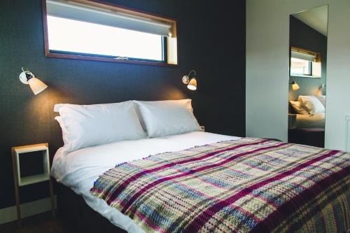 Jog Lodge 20 - 3 Bed Sea-View في ويك: غرفة نوم مع سرير مع بطانية ملونة عليه