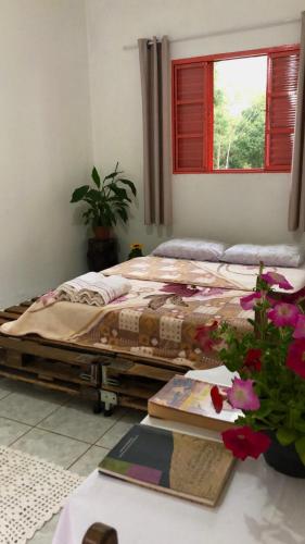 a bed in a room with a table and flowers at Atma Anna in Piedade