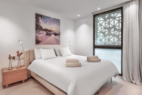 a white bedroom with a large bed and a window at Infinity 0-2 LUXE PARTIAL SEA VIEW 2B in Arona