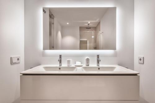 a white bathroom with a sink and a mirror at Infinity 0-2 LUXE PARTIAL SEA VIEW 2B in Arona