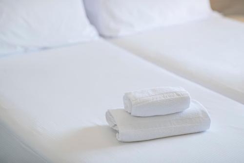 a couple of white towels sitting on a bed at Relais Ca Bago' -adults only in Costermano sul Garda