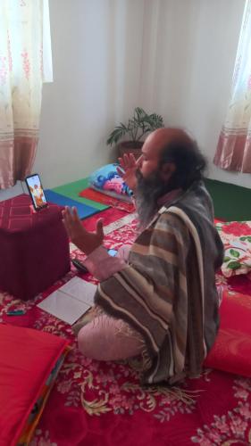 um homem sentado no chão usando um computador portátil em Budhanilkantha em Burhānilkantha