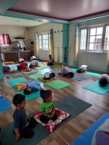 um grupo de crianças sentadas numa aula de ioga em Budhanilkantha em Burhānilkantha