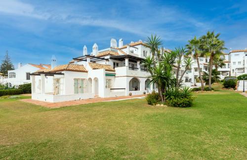 a large white house with a green yard at Playa Lucera in Sitio de Calahonda