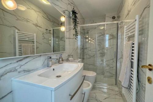 een witte badkamer met een wastafel en een douche bij Villa Caterina, Proche Monaco et imprenable vu mer in Beausoleil