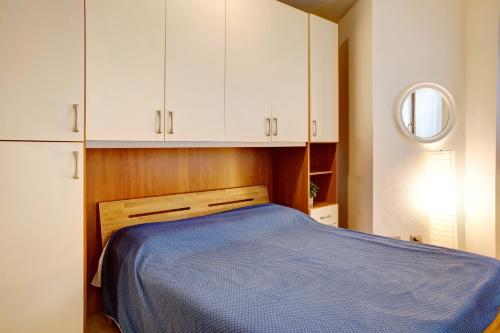 a bedroom with a blue bed and white cabinets at Foresteria al Cantun in Sondrio