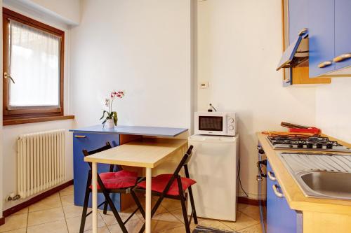 a small kitchen with a table and a microwave at Foresteria al Cantun in Sondrio