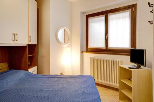 a bedroom with a blue bed and a window at Foresteria al Cantun in Sondrio