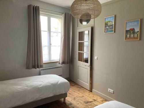 a bedroom with a bed and a window at Maison familiale et cosy à la mer in Saint-Valery-sur-Somme