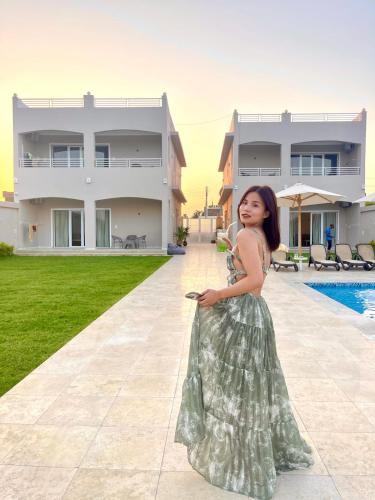 a young girl in a dress standing in front of a house at Royal Nile Villas - Pool View Apartment 2 in Luxor