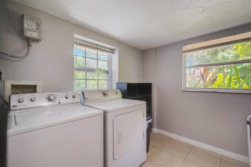 ブレーデントンにあるSerenity Of The Seaの洗濯機、乾燥機、窓が備わるランドリールームです。