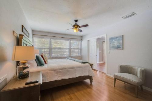 ブレーデントンにあるSerenity Of The Seaのベッドルーム1室(シーリングファン、椅子、ベッド1台付)