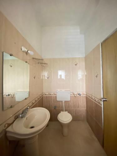 a bathroom with a sink and a toilet and a mirror at Jewel Resort in Lonavala