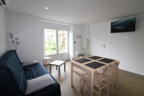 a living room with a couch and a table at Appartement RDC in Remoncourt