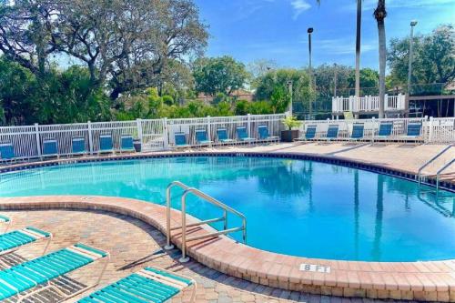 a large swimming pool with blue lounge chairs around it at Shorewalk Condominium in Bradenton