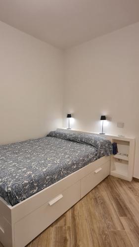 a bedroom with a bed with two lamps on it at Attico vista mare mozzafiato in Porto Santo Stefano