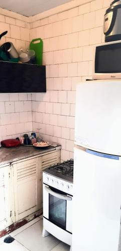 a kitchen with a stove and a white refrigerator at Sétimo Hostel 7 in Sao Paulo