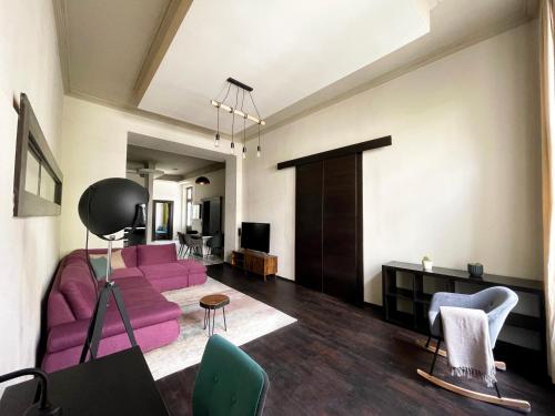 een woonkamer met een paarse bank en stoelen bij Deluxe Cosmopolitan Apartment Budapest, with Private Parking in Boedapest