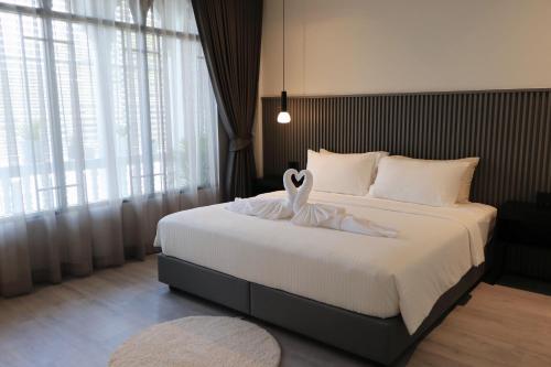 una camera da letto con un letto decorato con cigno di arche second floor a Ban Riang