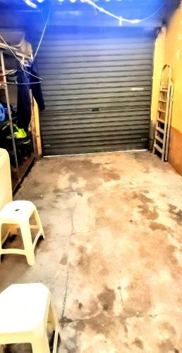 an empty garage with a garage door and two stools at Sétimo Hostel 7 in Sao Paulo