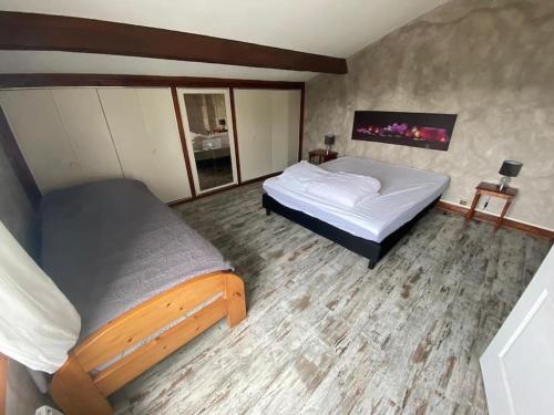 a bedroom with two beds and a flat screen tv at La maison du Coteau in Bourré