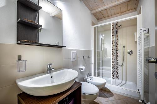 ein Bad mit einem Waschbecken, einem WC und einer Dusche in der Unterkunft Roommo Beccaria in Florenz