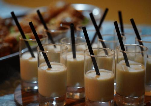 a row of glasses filled with brown drinks with black straws at PARAISO DAKHLA in Dakhla