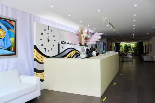 a lobby with a reception desk with a vase of flowers at Hotel Bucaramanga Plaza in Bucaramanga